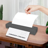 A hand places a white contract agreement paper onto a gray thermal printer on a wooden desk.