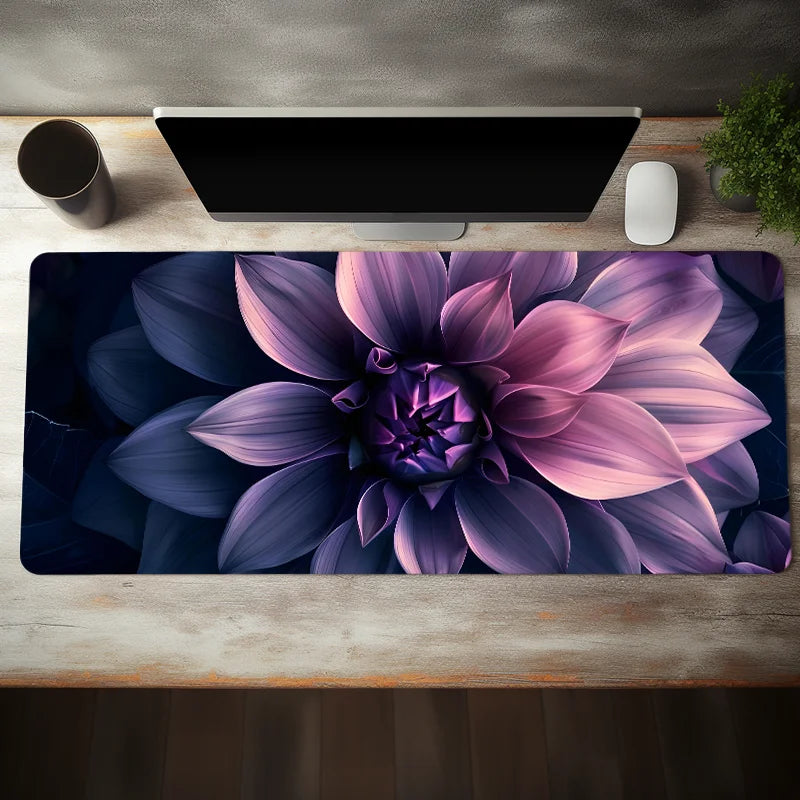 A purple and pink aesthetic floral mouse pad with a non-slip rubber base placed on a wooden desk.