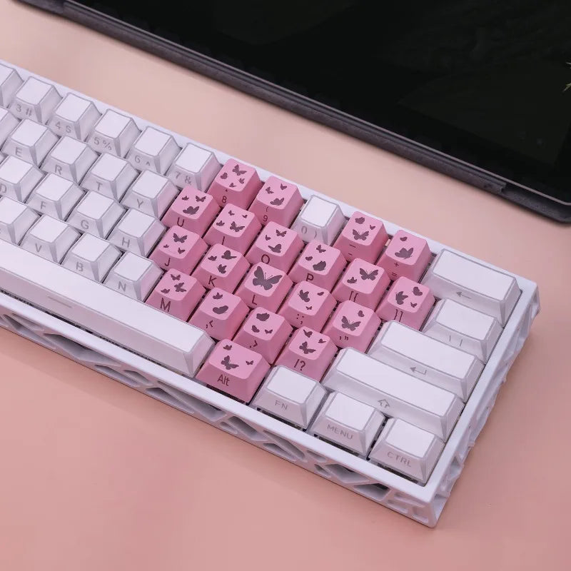 Nahaufnahme von rosa Butterfly-Keycaps, arrangiert in einer weißen Kunststoffschale für mechanische Tastaturen.