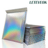A stack of iridescent rainbow foil bubble mailers for gifts and documents.