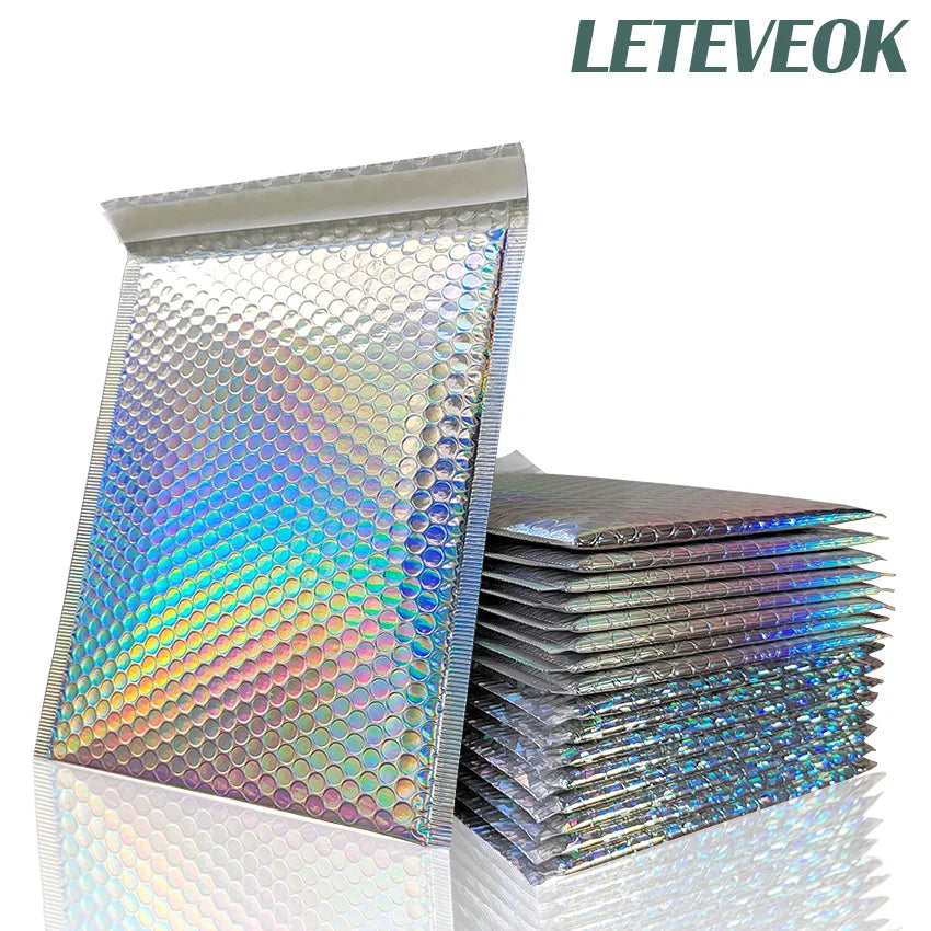 A stack of iridescent rainbow foil bubble mailers for gifts and documents.