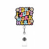 A colorful badge reel featuring the text IDK I JUST WORK HERE in a distressed font with floral accents.