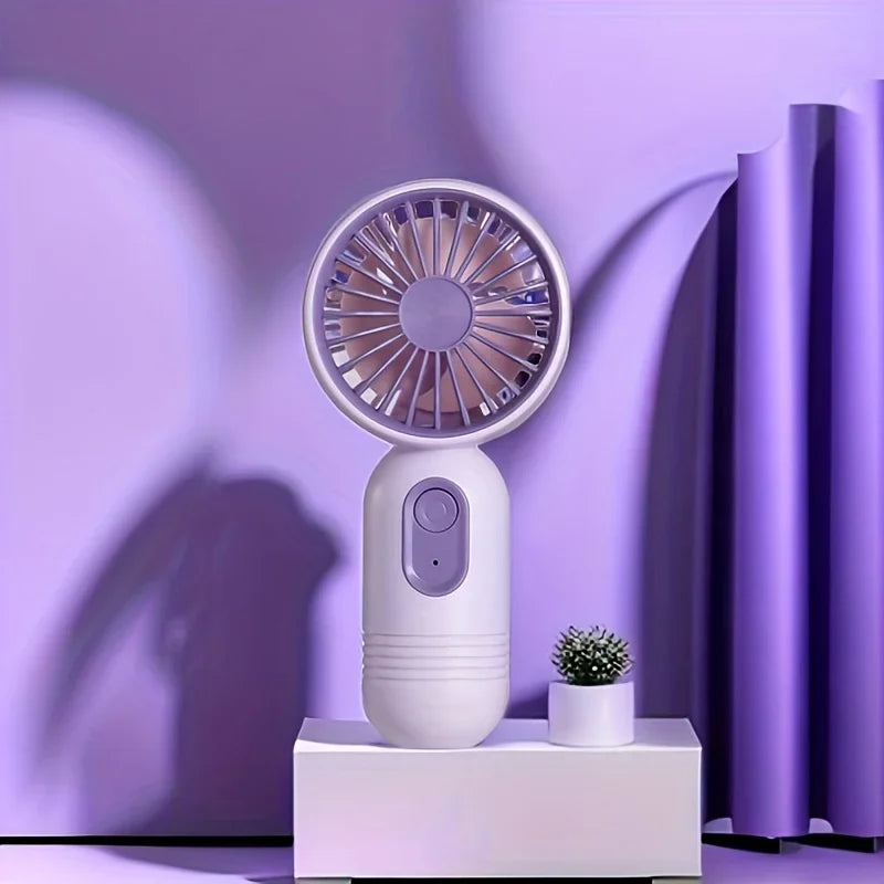 Weißer tragbarer USB-Lade-Mini-Handventilator mit lila Gitter auf weißem Untergrund.