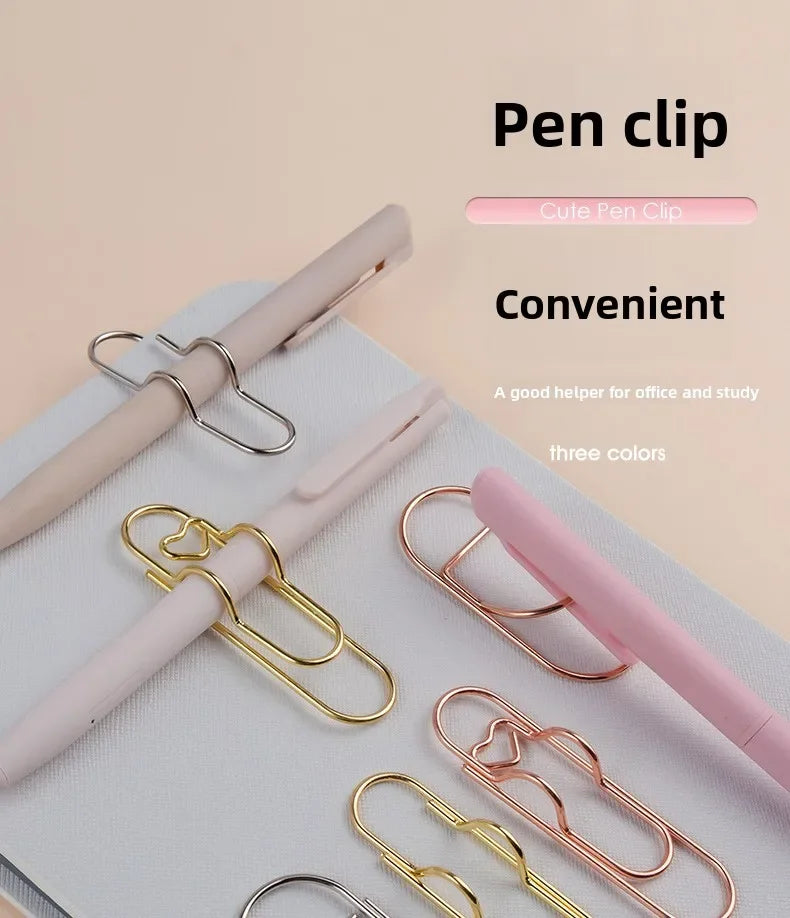 A collection of elegant metal pen clips in various colors, including gold and pink, displayed on a white surface.