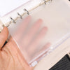 A hand holds a clear PVC zipper binder with transparent pockets for cash and small items.