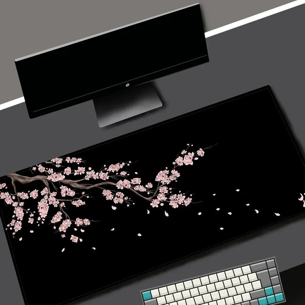 Black gaming mouse pad with a pink cherry blossom design and a white keyboard visible.