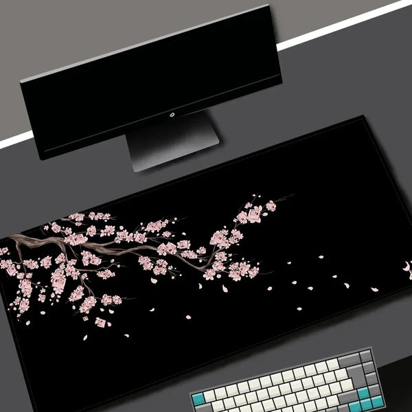 Black gaming mouse pad with a pink cherry blossom design and a white keyboard visible.