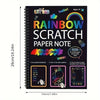 A black spiral notebook titled Rainbow Scratch Paper Note featuring colorful art and stylus sticks for children