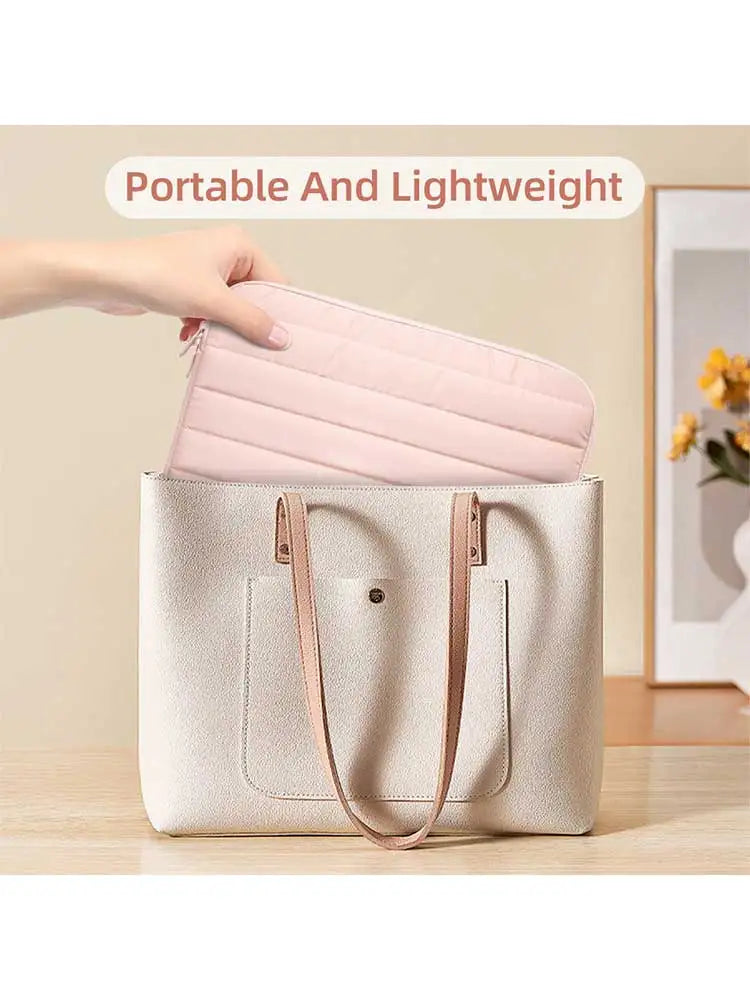 A light pink padded laptop sleeve is being placed into a beige canvas tote bag.