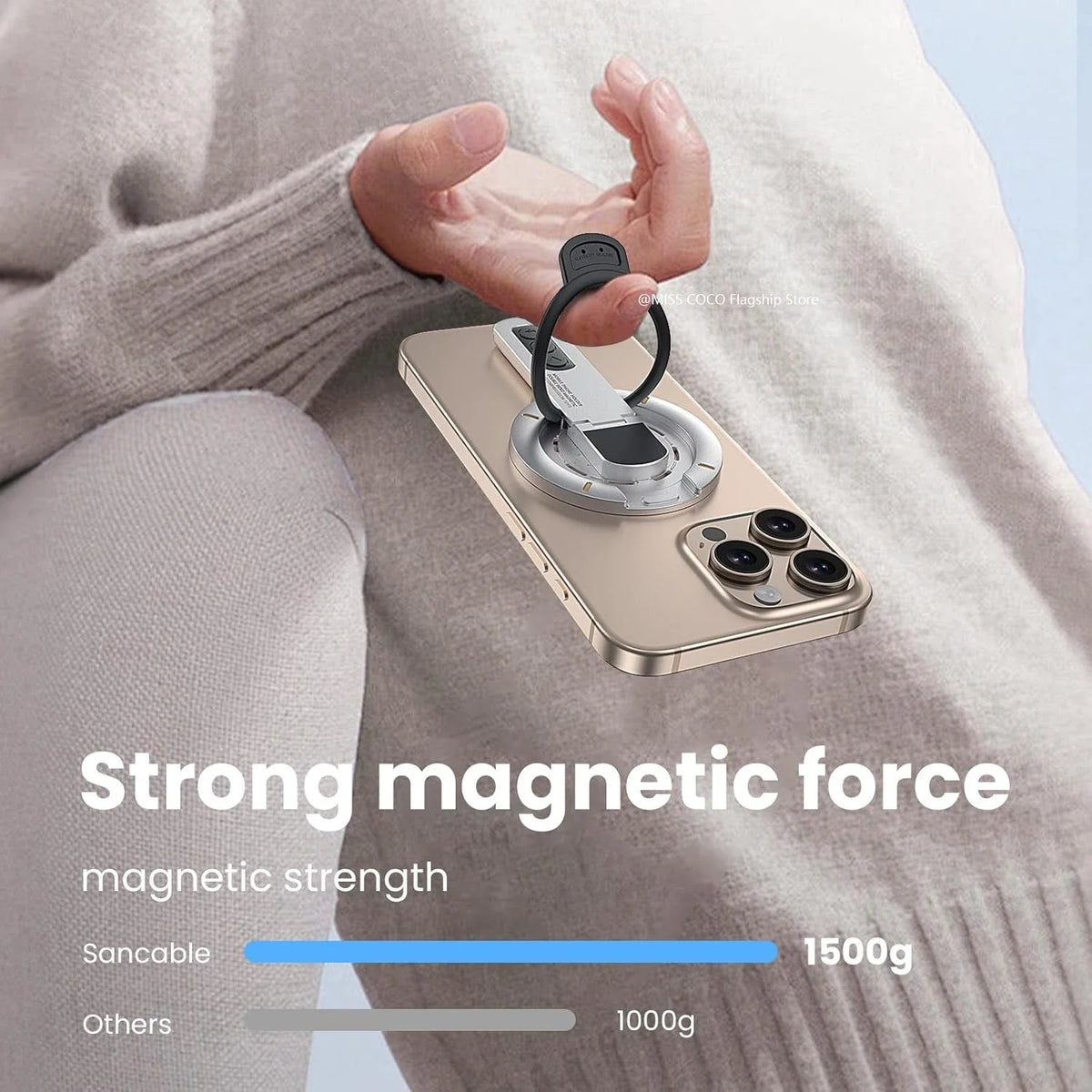 A hand holds a dual-sided magnetic phone ring holder demonstrating strong magnetic force for phone support.