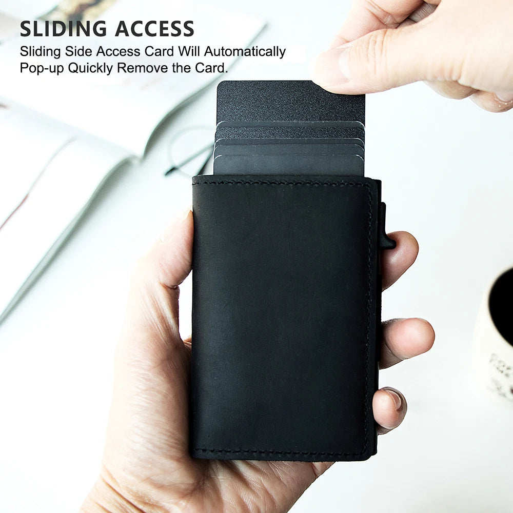 A hand holds a black slim leather wallet with a card pop-up feature.