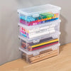 A stack of clear plastic storage boxes with lids containing various colored markers and pencils for office and craft supplies