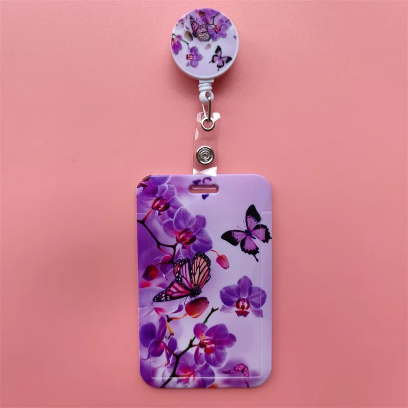 A purple phone case featuring a floral pattern, attached to a silver clip.