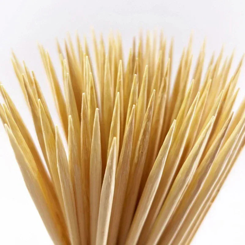 A close-up view of a set of natural bamboo skewers with various lengths.