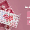 A pink mechanical gaming keyboard with RGB backlight and roses is displayed on a pink background.