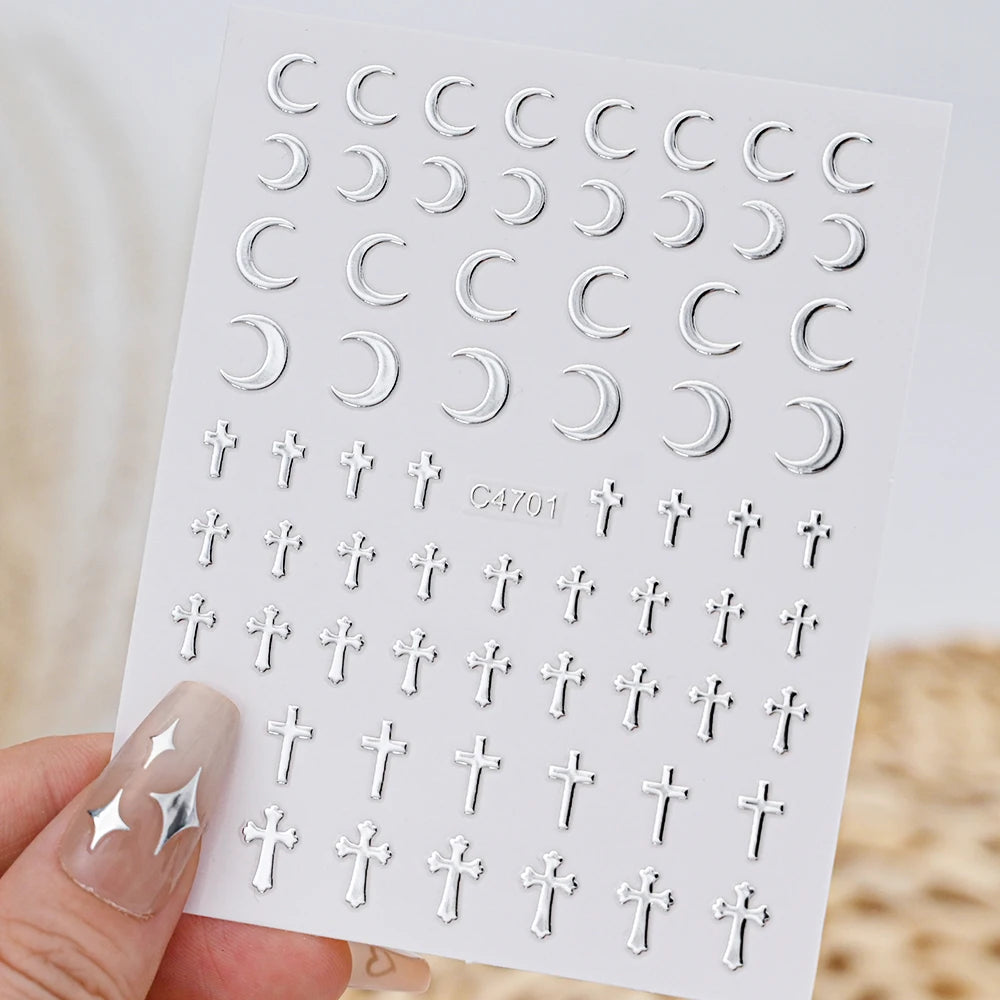 A sheet of metallic 3D star nail art stickers showing various silver and gold cross shapes.