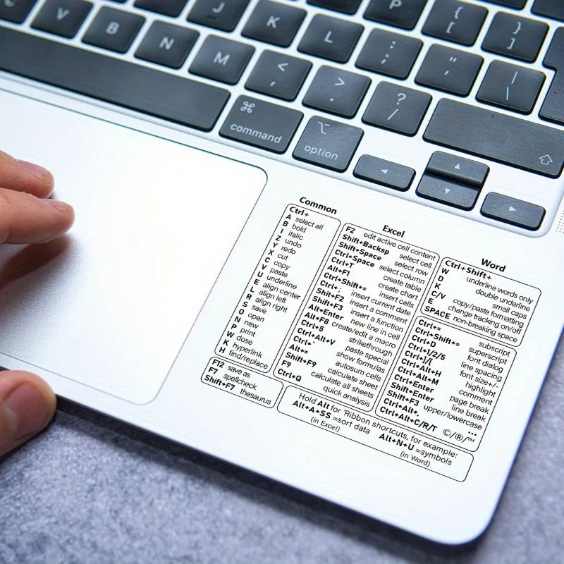 A close-up view of a laptop keyboard with vinyl shortcut stickers for Windows, Excel, and Word