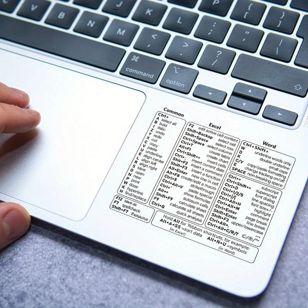 A close-up view of a laptop keyboard with vinyl shortcut stickers for Windows, Excel, and Word