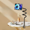 A black rotating tablet and phone stand with a flexible spiral base resting on a marble table.