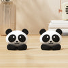 Two black and white panda desk cable organizers sitting on a wooden surface.