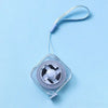 A clear plastic compact retractable measuring tape with a purple connector and a silver-colored wheel is shown against a ligh