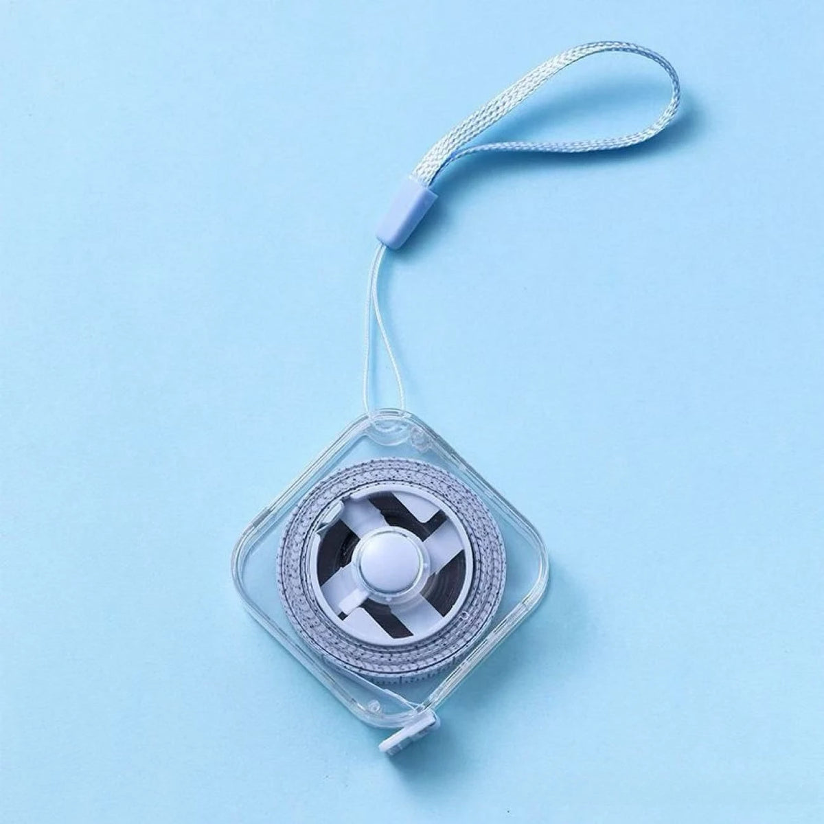 A clear plastic compact retractable measuring tape with a purple connector and a silver-colored wheel is shown against a ligh