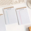 Un escritorio blanco con varias libretas de notas y un teclado.