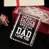 A clear glass keepsake box filled with white paper shreds, resting on a dark surface.