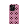 A pink phone case with a dark polka dot pattern and a clear back, featuring a camera module.