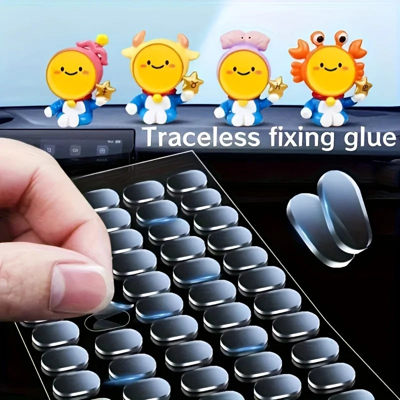 A hand holds a transparent double-sided mounting tape next to several cute, smiling silicone figures.