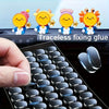 A hand holds a transparent double-sided mounting tape product next to several cute, smiling silicone figures.