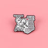 A black enamel lapel pin featuring two figures and text about having enough books versus not having them.