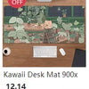 A green patterned desk mat featuring a frog design, displayed on a wooden desk with a computer monitor and keyboard.