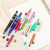 A collection of colorful beaded rubber touch ballpoint pens arranged on a white lined notepad.