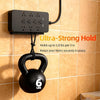 A black heavy duty double-sided nano adhesive tape hook holding a 6 lbs weight on a tiled wall.