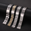 Four stainless steel watch bands with gold accents are displayed on a dark surface.