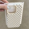 A hand holds a white phone case with a polka dot pattern and a soft-touch grip feature.