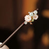 Une épingle à cheveux avec un bâton en bois présente des accessoires capillaires floraux faits de perles de verre rose pâle e