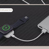 A smartwatch is shown being charged by a magnetic wireless charger connected to a power bank.