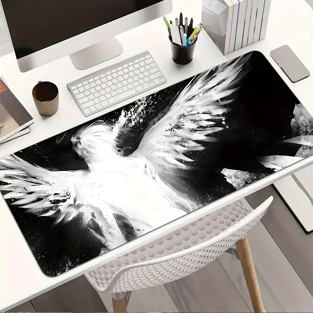 A black and white artistic angel wing desk mat mouse pad displayed on a white desk.