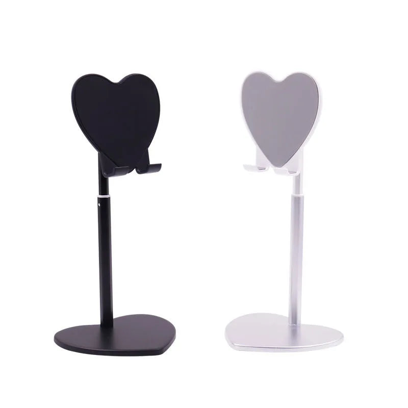 A black adjustable desktop phone and tablet stand with heart-shaped holders.