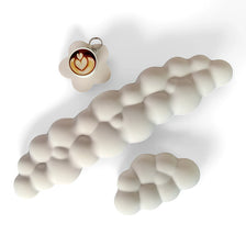 Un set de trois repose-poignets pour clavier en forme de nuage blanc, dont un avec une décoration latte art.