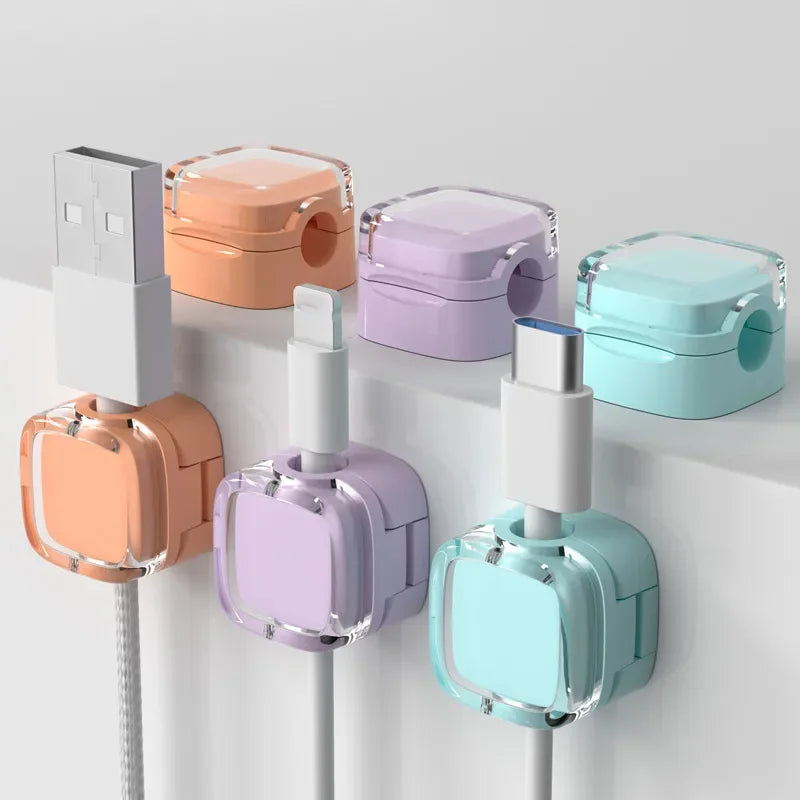 A set of magnetic cable management clips in various pastel colors, including peach, lavender, and mint green, mounted on a wh
