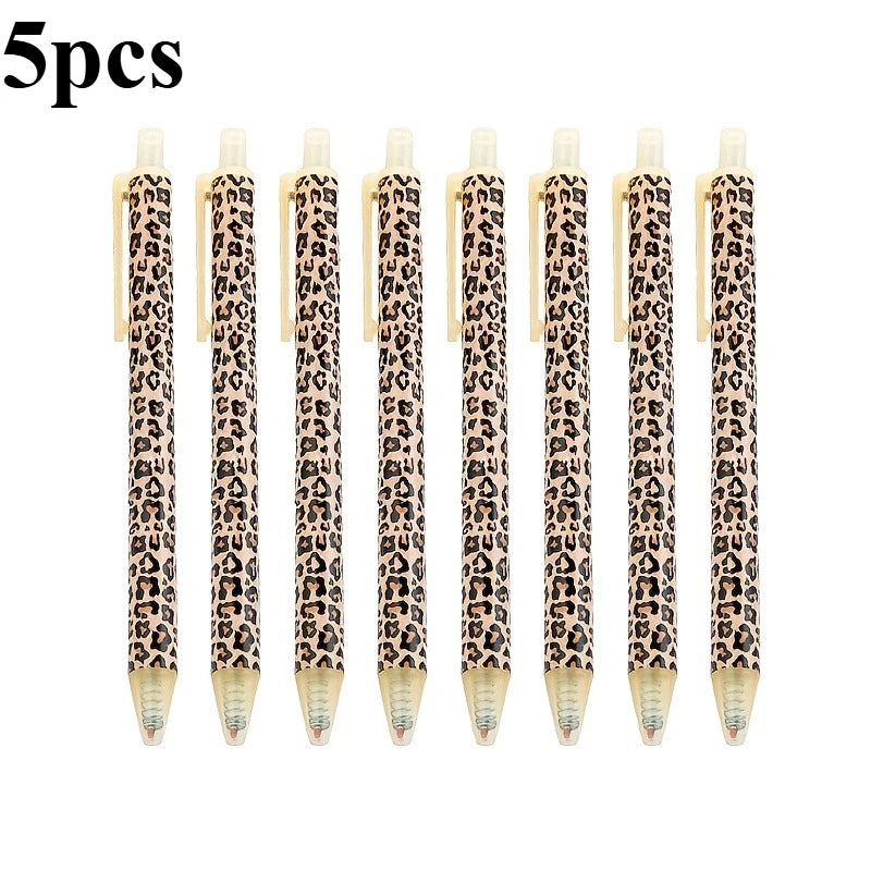 Five leopard print retractable ballpoint pens with black ink.