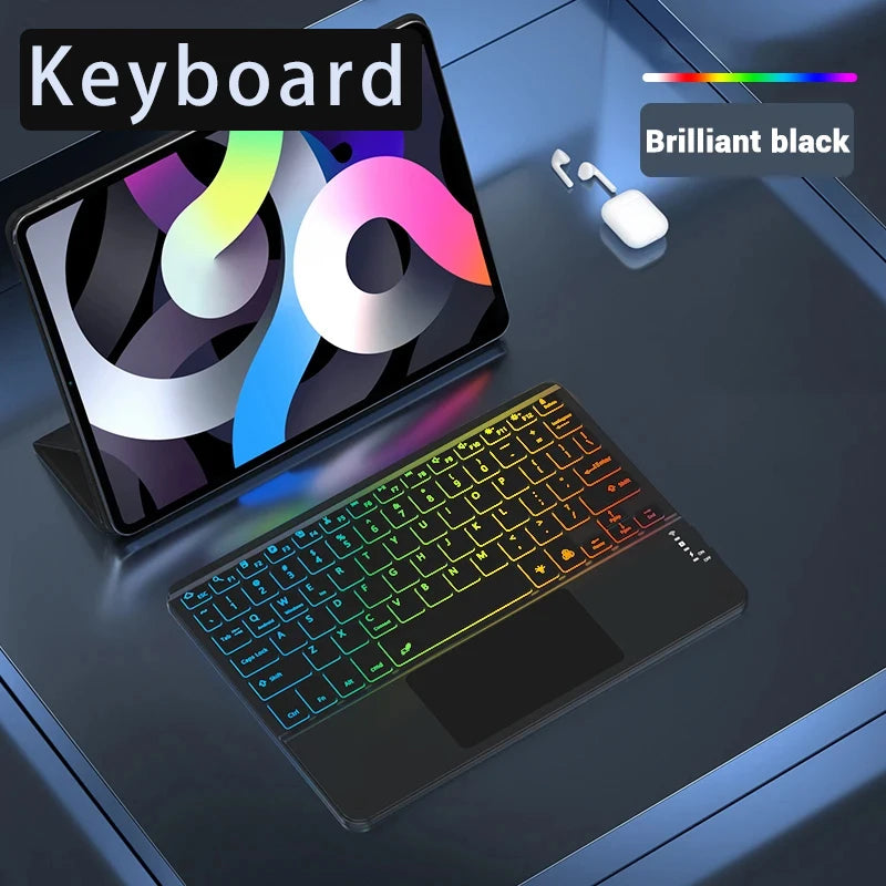 A black wireless keyboard with a touchpad and illuminated keys is shown next to a tablet displaying a colorful graphic.