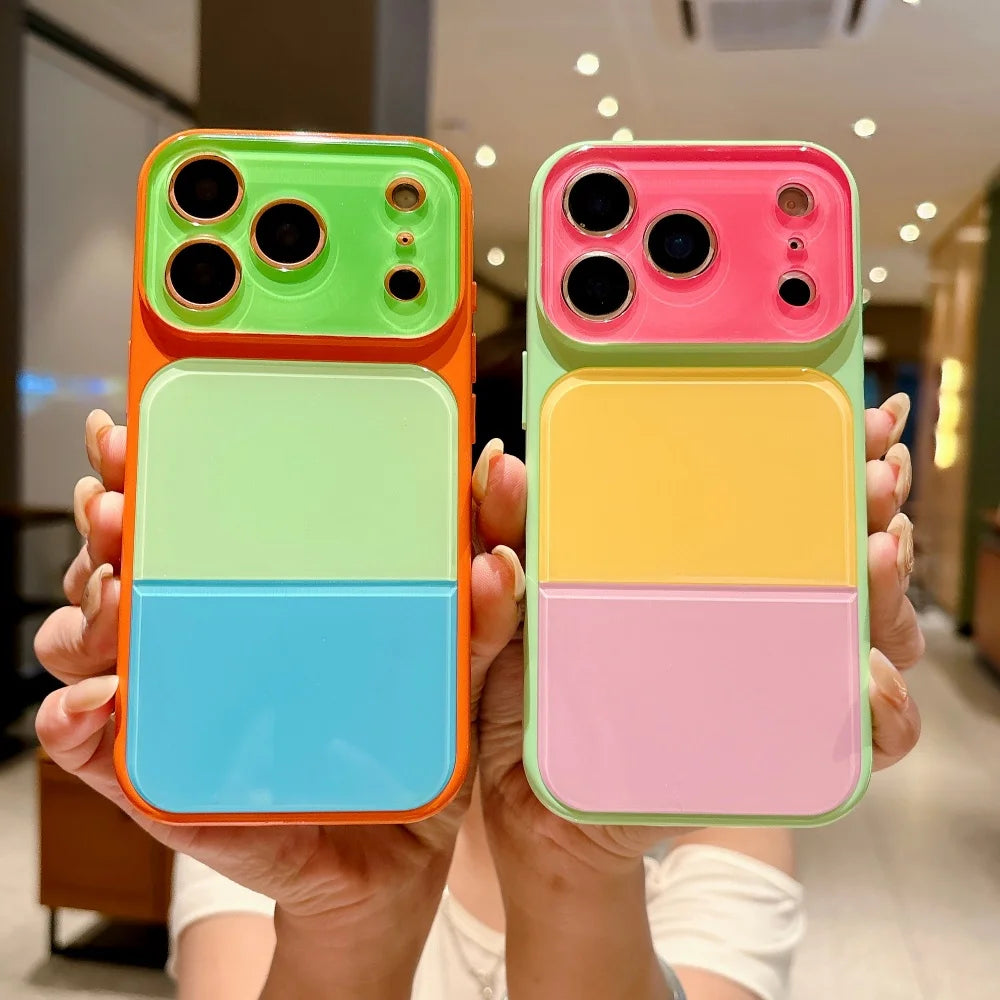 A hand holds an iPhone in a colorful block acrylic case featuring orange, green, blue, and pink sections.