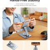 A person holds a orange phone holder stand on a wooden table demonstrating hands-free stability.