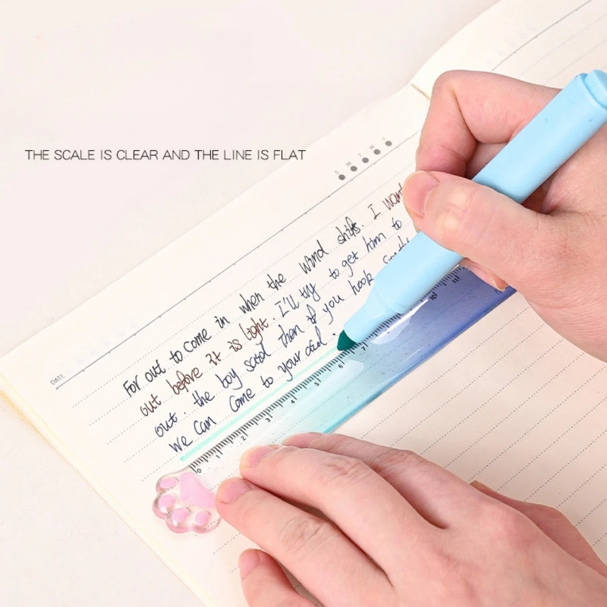 A hand uses a blue straight ruler with a gradient scale to measure text on a notebook page.