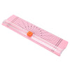 Pink portable manual paper trimmer with a grid and orange button for crafting and scrapbooking