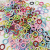 A collection of colorful spring clasps and rings in various shades of pink, green, yellow, purple, and black.